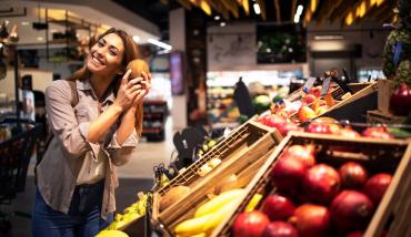 Mujer comprando fruta en el supermercado para pagarla con MODO y la Mutual del Club Atlético Pilar